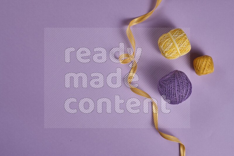 مجموعة من أدوات الخياطة والتفصيل صفراء وأرجوانية اللون على خلفية أرجوانية