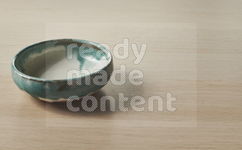 A multicolored pottery bowl on light wooden background