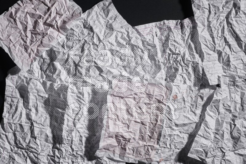 Crumpled notebook sheet on black background