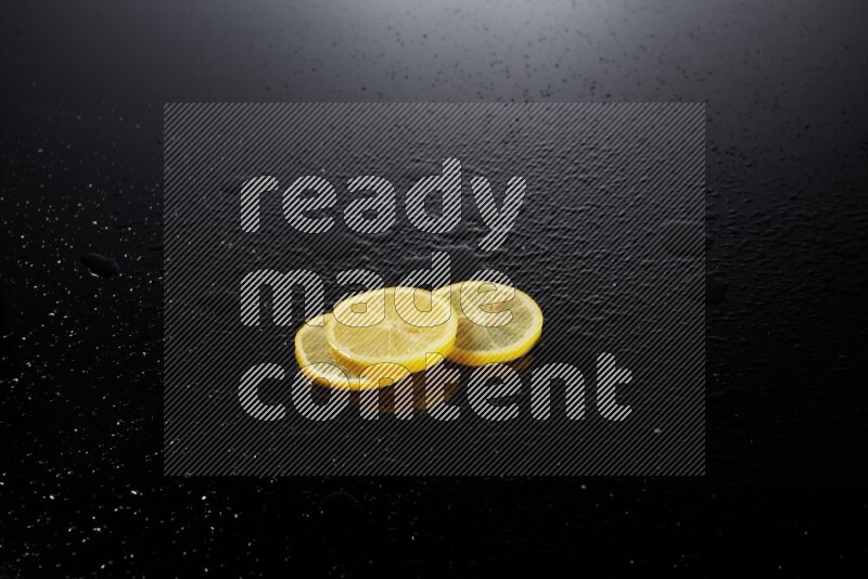 Lemon slices with water drops, and droplets on black background