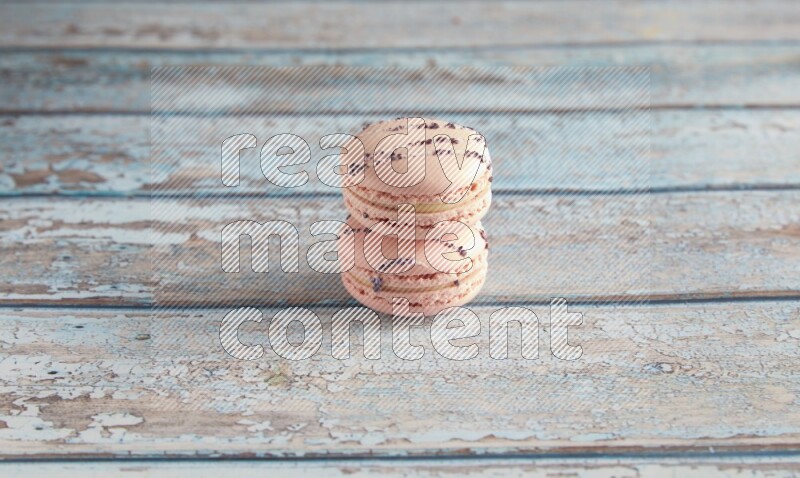45º Shot of two pink orange blossom macarons on light blue wooden background