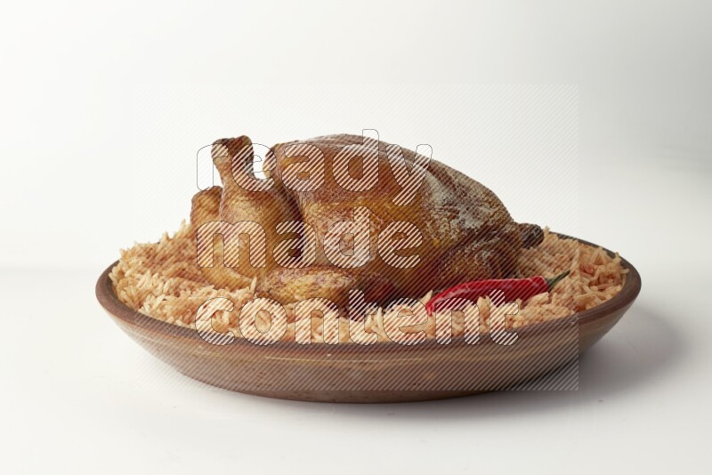 red basmati Rice with whole roasted chicken on a pottery plate direct on white background