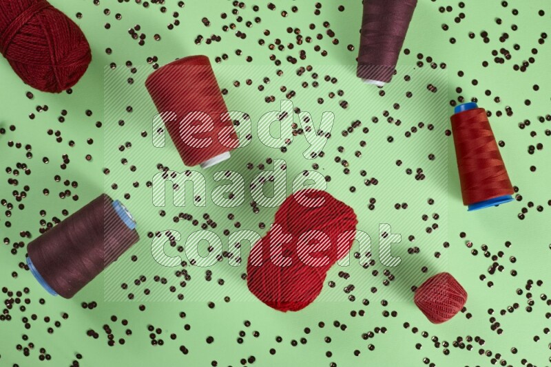 A red collection of sewing and tailoring tools arranged on a green background