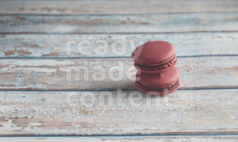 45º Shot of two Red Cherry macarons on light blue wooden background