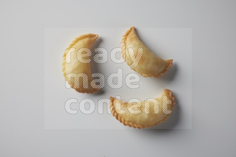 Three fried sambosa from a top angle on a white background