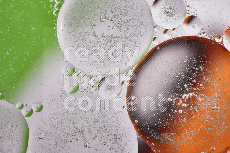 Close-ups of abstract oil bubbles on water surface in shades of orange, green and white
