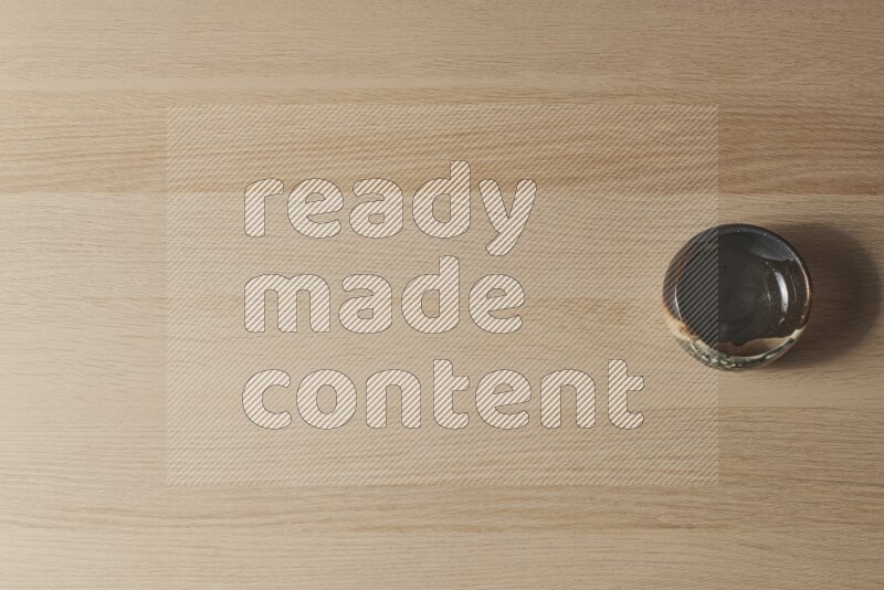 A multicolored pottery bowl on light wooden background