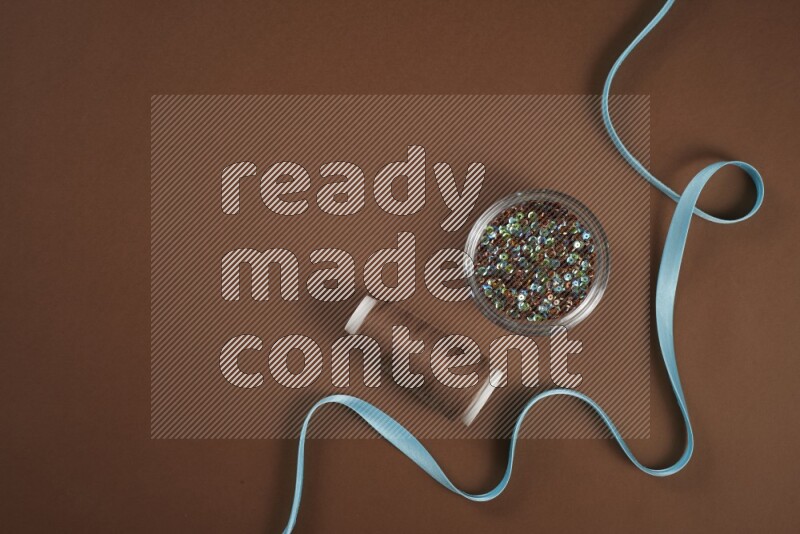 A blue collection of sewing and tailoring tools arranged on a brown background