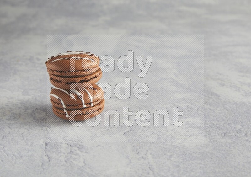 45º Shot of two Brown white marbleChocolate Caramel macarons  on white  marble background