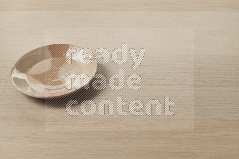 A multicolored pottery plate on light wooden background