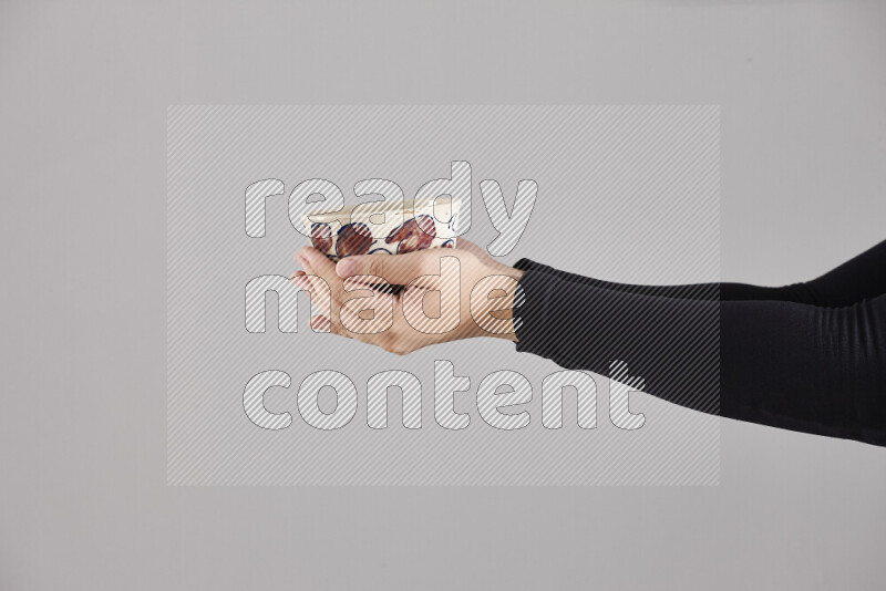 A woman in black abaya holding different pottery essentials in different positions