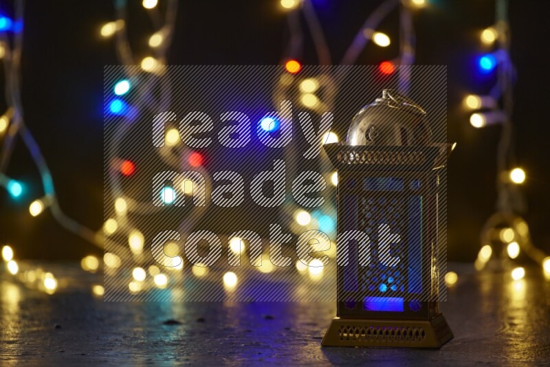 A traditional ramadan lantern surrounded by glowing fairy lights in a dark setup