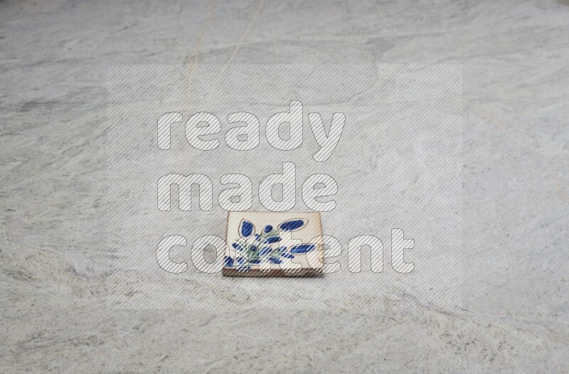 Top view shot of a pottery coaster\ tile on beige marble flooring