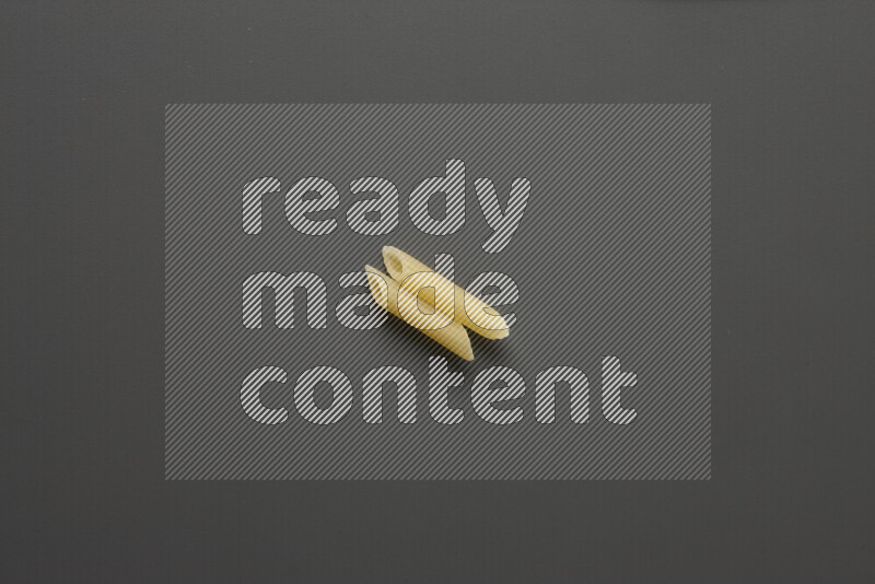 Mini penne pasta on grey background