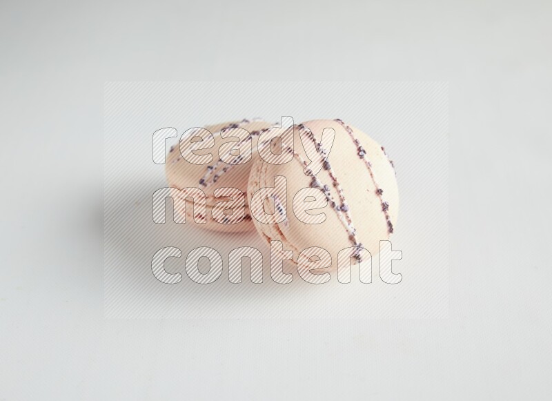 45º Shot of two pink orange blossom macarons on white background
