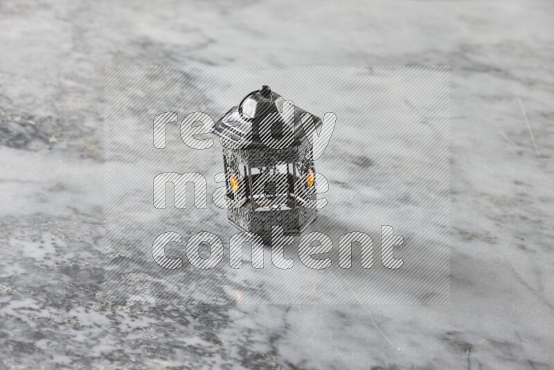 A lantern placed on a grey marble background