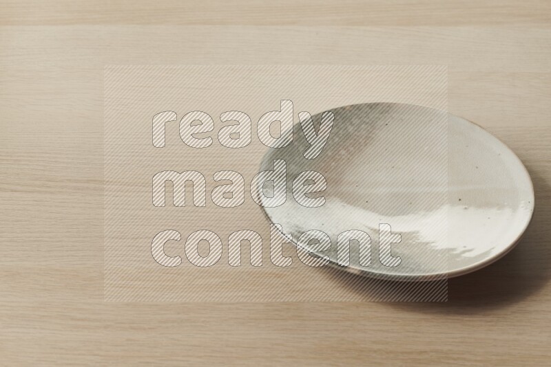 A multicolored pottery plate on light wooden background