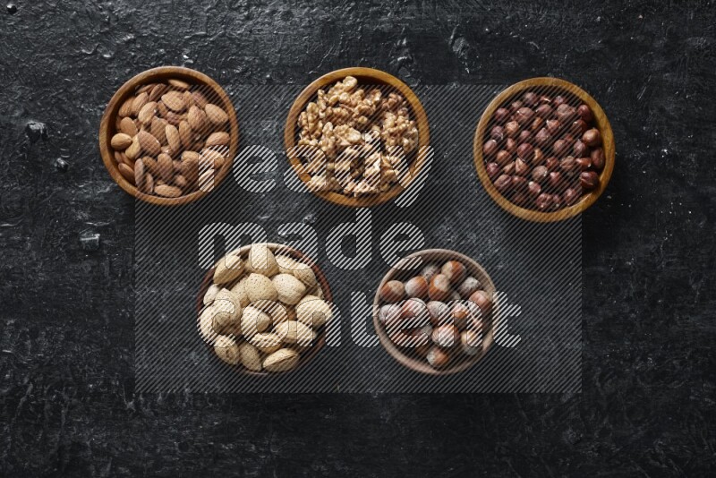 Nuts in wooden bowls in a dark setup