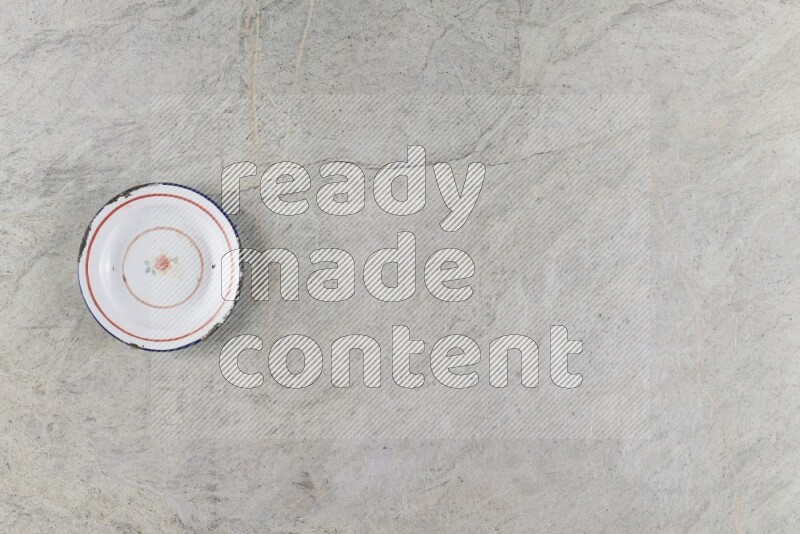 صحن معدني عتيق على خلفية من الرخام الرمادي