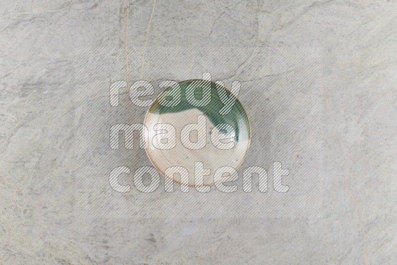 A decorative pottery plate on grey marble background