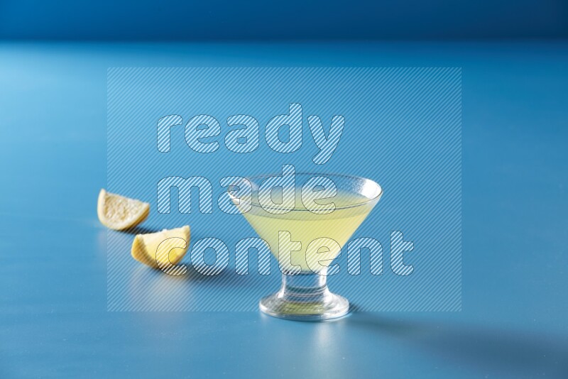 glass of lemon juice on blue background