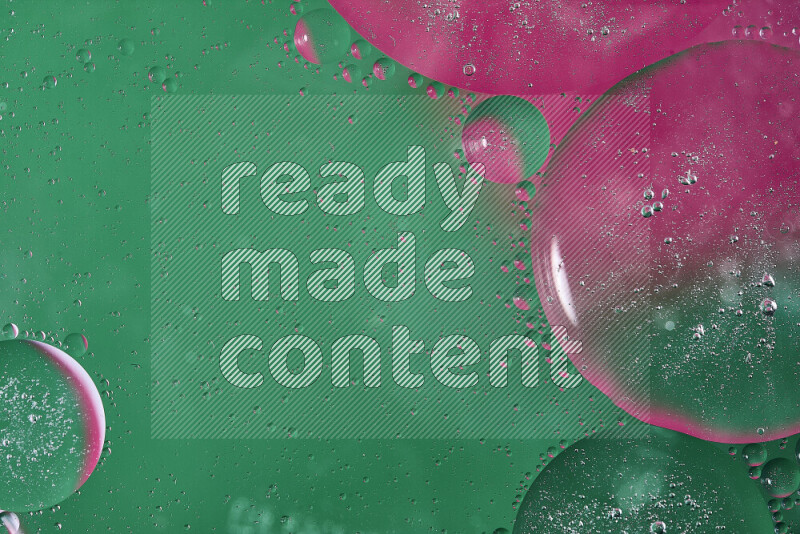 Close-ups of abstract oil bubbles on water surface in shades of green and pink