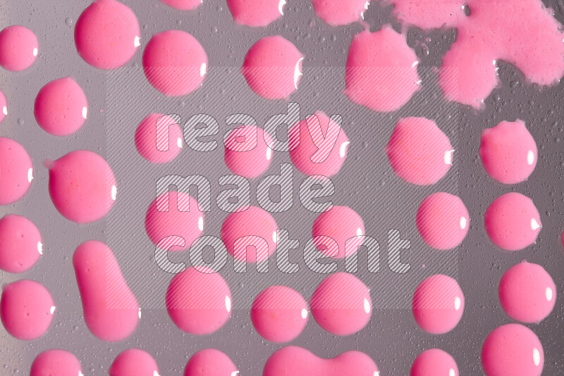Close-ups of abstract pink paint droplets on the surface