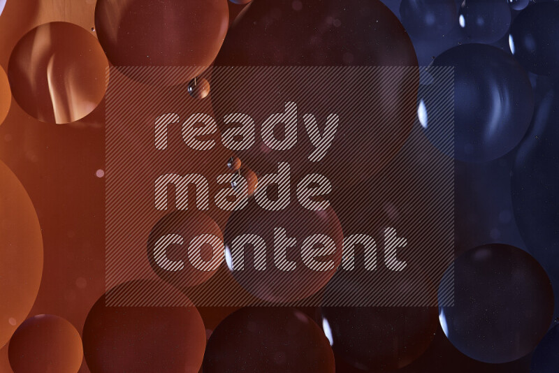 لقطات مقربة لفقاعات من الزيت على سطح الماء باللون الأسود والبرتقالي