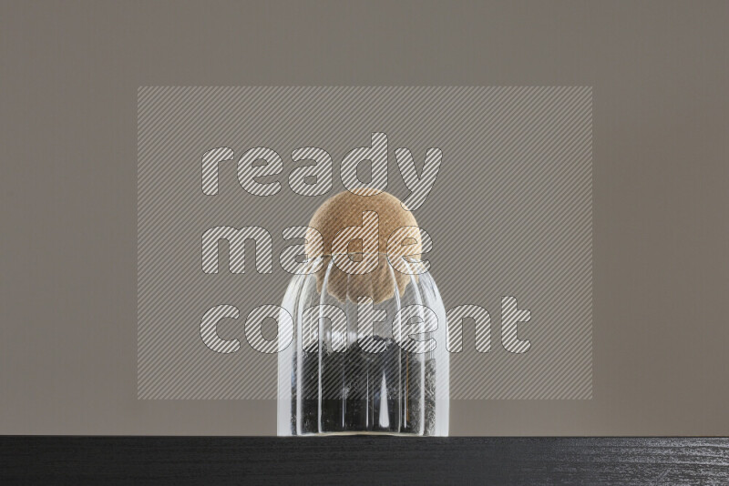 Dried plums in a glass jar on black background