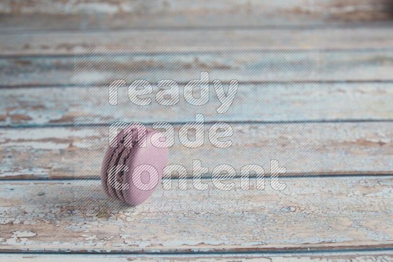 45º Shot of Purple Blueberry macaron on light blue wooden background