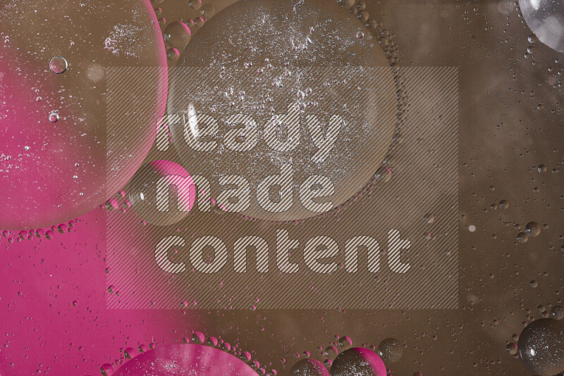 لقطات مقربة لفقاعات من الزيت على سطح الماء باللون الوردي والبني