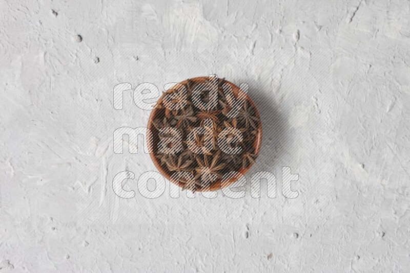 Star Anise in a wooden bowl on white flooring