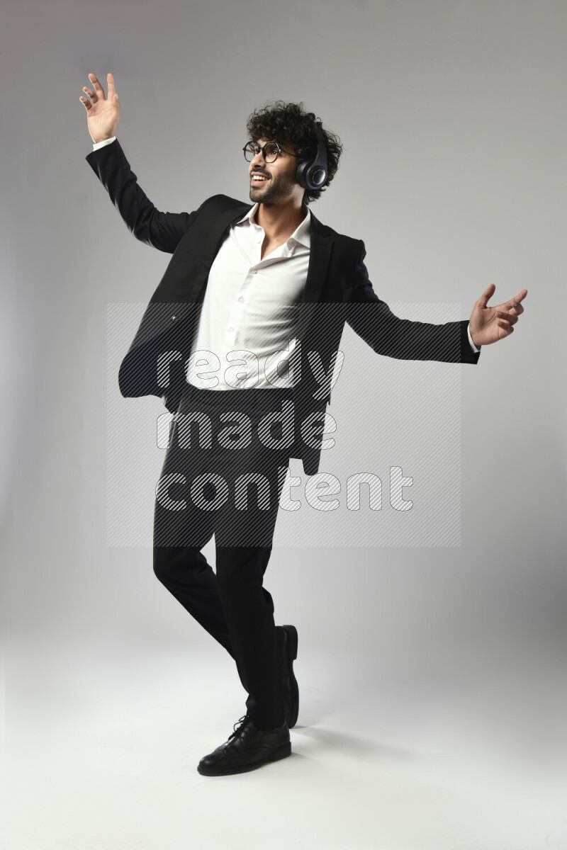 رجل يرتدي ملابس رسمية يضع سماعات رأس علي خلفية بيضاء