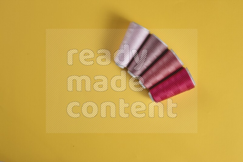 مجموعة من أدوات الخياطة والتفصيل زهرية اللون على خلفية صفراء