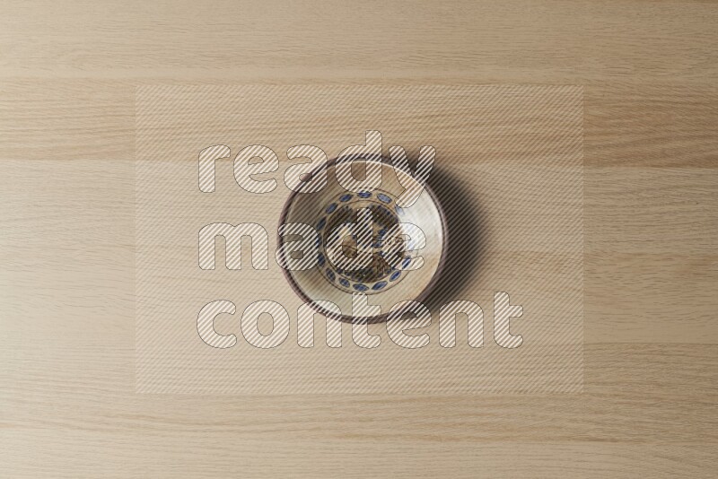 A decorative pottery plate on light wooden background