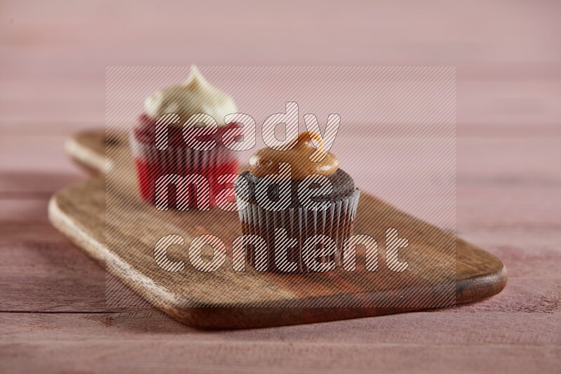 Chocolate mini cupcake topped with peanut butter on a wooden board