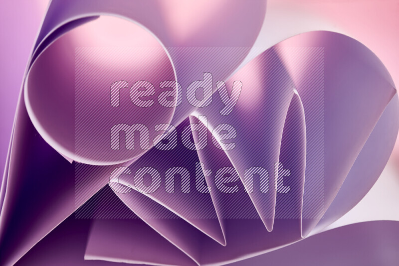 An artistic display of paper folds creating a harmonious blend of geometric shapes, highlighted by soft lighting in purple tones