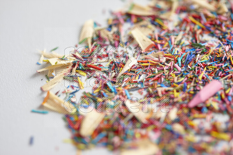 This image showcases a vibrant multicolored pencil shavings scattered on grey background