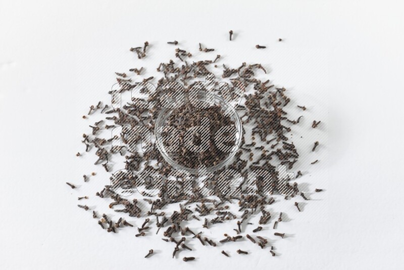 A glass bowl full of cloves on a white flooring