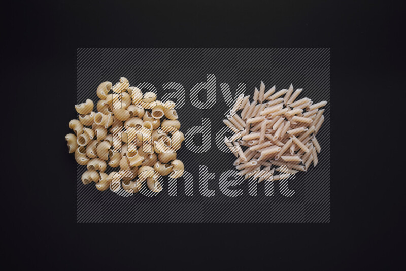 Different pasta types in bunches on black background