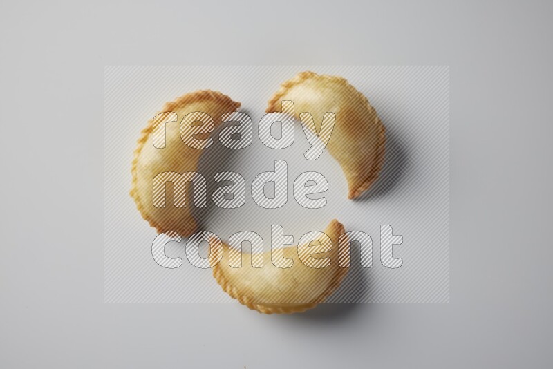 Three fried sambosa from a top angle on a white background