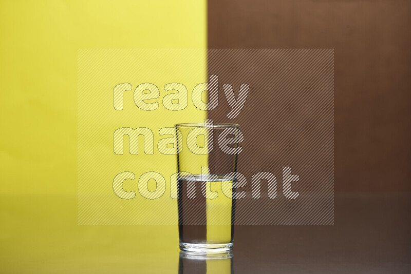 The image features a clear glassware filled with water, set against yellow and brown background