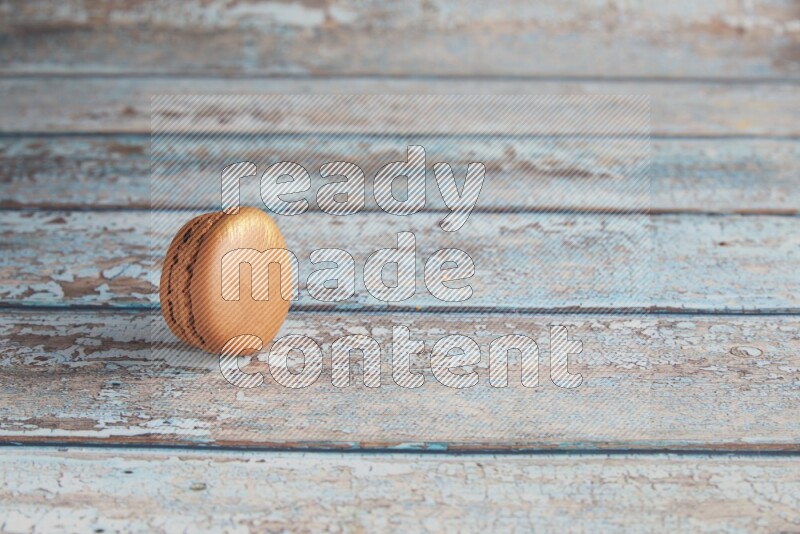 45º Shot of Brown Coffee macaron on light blue wooden background