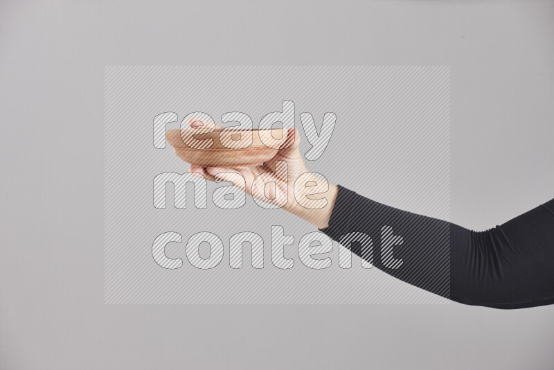 A woman in black abaya holding different wooden essentials in different positions