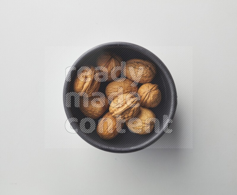 Top-view shot of walnut in a container on white background