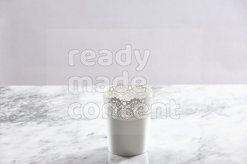 An empty white plant pot on grey marble background