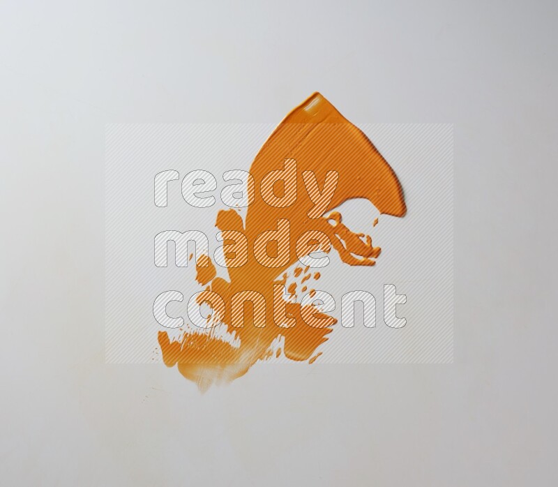 An orange single random painting knife stroke on white background