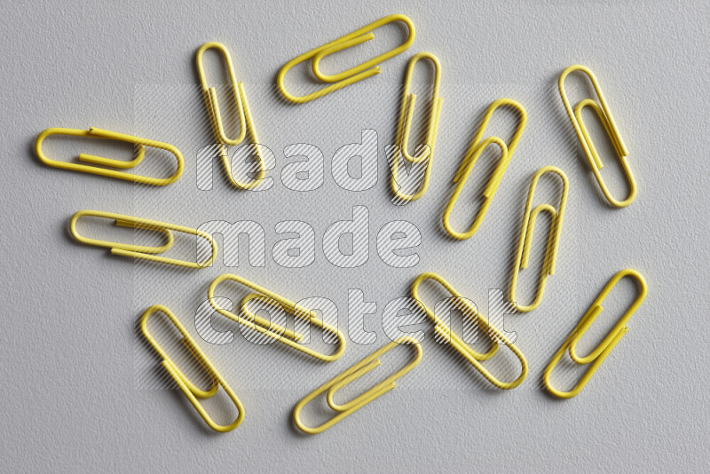Yellow paper clips isolated on a grey background