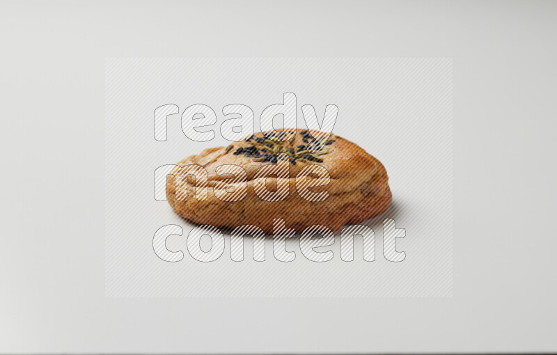 Hasawi cookie field with date and decorated by black seed and Anise grain on a white background