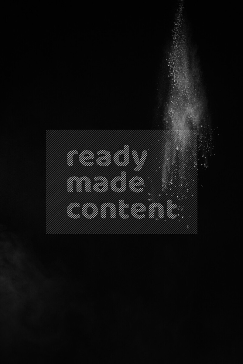 A side view of white powder explosion on black background